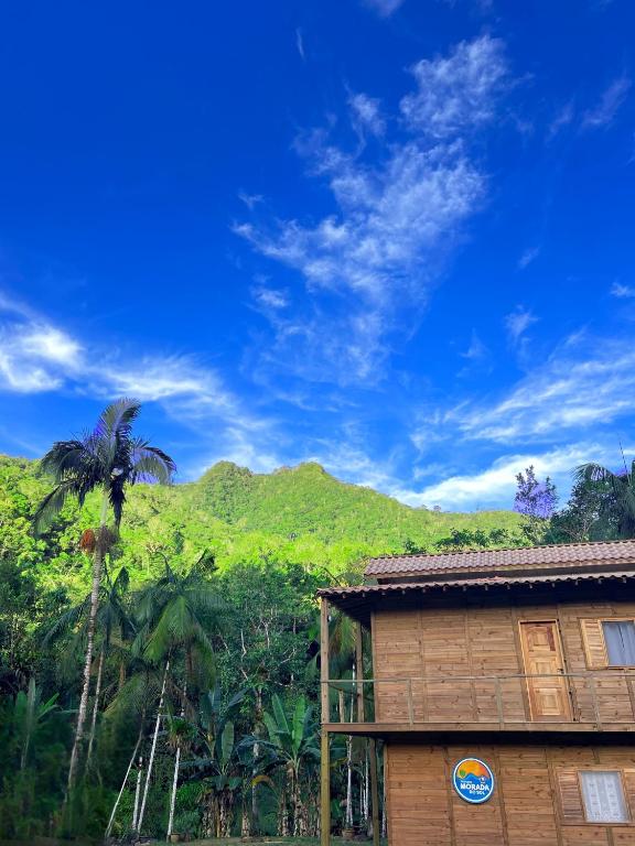 een gebouw met een palmboom voor een berg bij Morada do Sol Petar in Iporanga