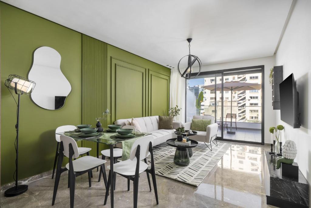 a living room with green walls and a table and chairs at Bright Modern Studio, Gauthier in Casablanca