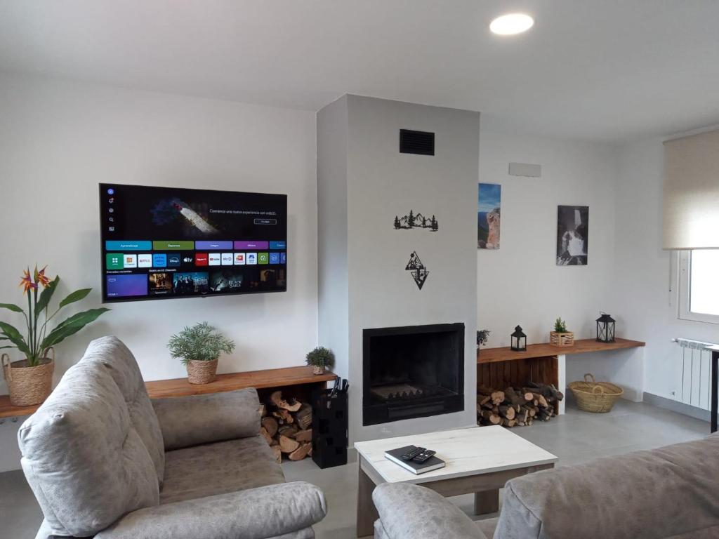 un soggiorno con un divano e una TV a parete di Alojamiento Rural El Lentisco 