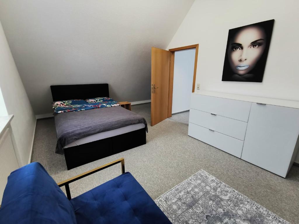 een slaapkamer met een bed en een commode met een gezicht op de muur bij Lounge house in Burgau