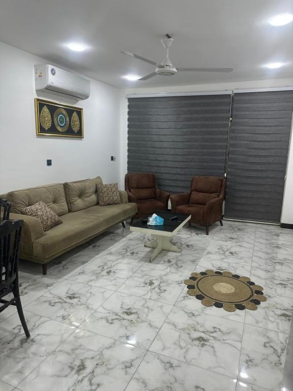 a living room with a couch and chairs and a table at Jadriya Serviced Residences in Baghdad