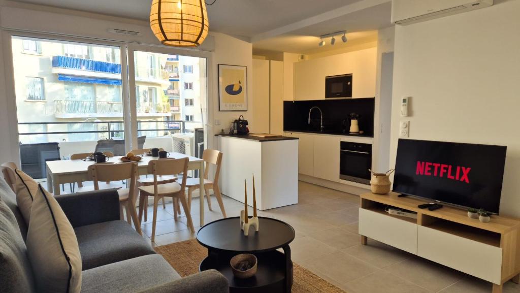un salon avec un canapé, une télévision et une table dans l'établissement T3 neuf climatisé avec parking à Nice, à Nice
