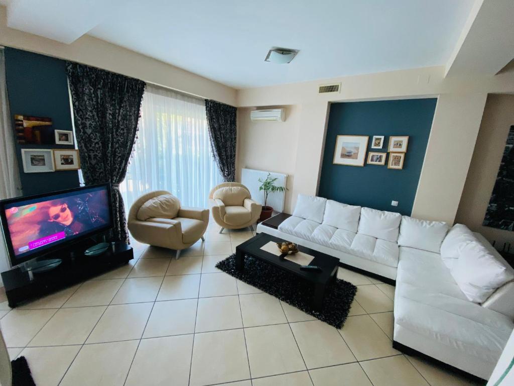 ein Wohnzimmer mit einem weißen Sofa und einem Fernseher in der Unterkunft Apartament Modern & Spatios - La 2 minute de Mare in Mamaia Nord – Năvodari