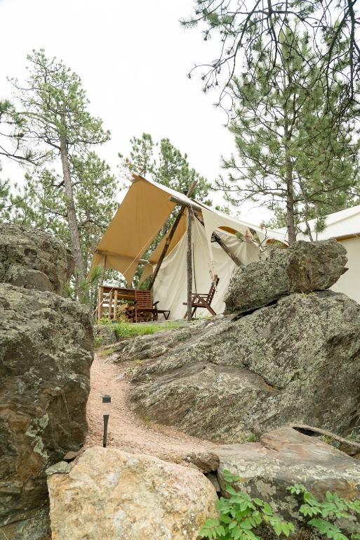 a tent with some rocks in front of it at Under Canvas Mount Rushmore in Keystone