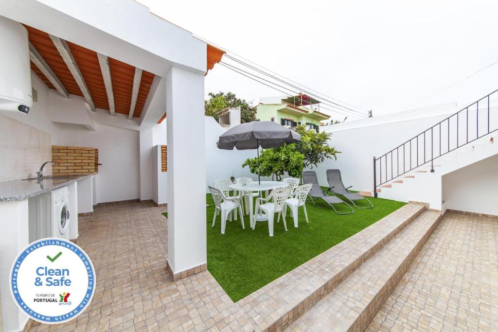 a patio with a table and chairs and an umbrella at D02 - Carrob Street House in Lagos