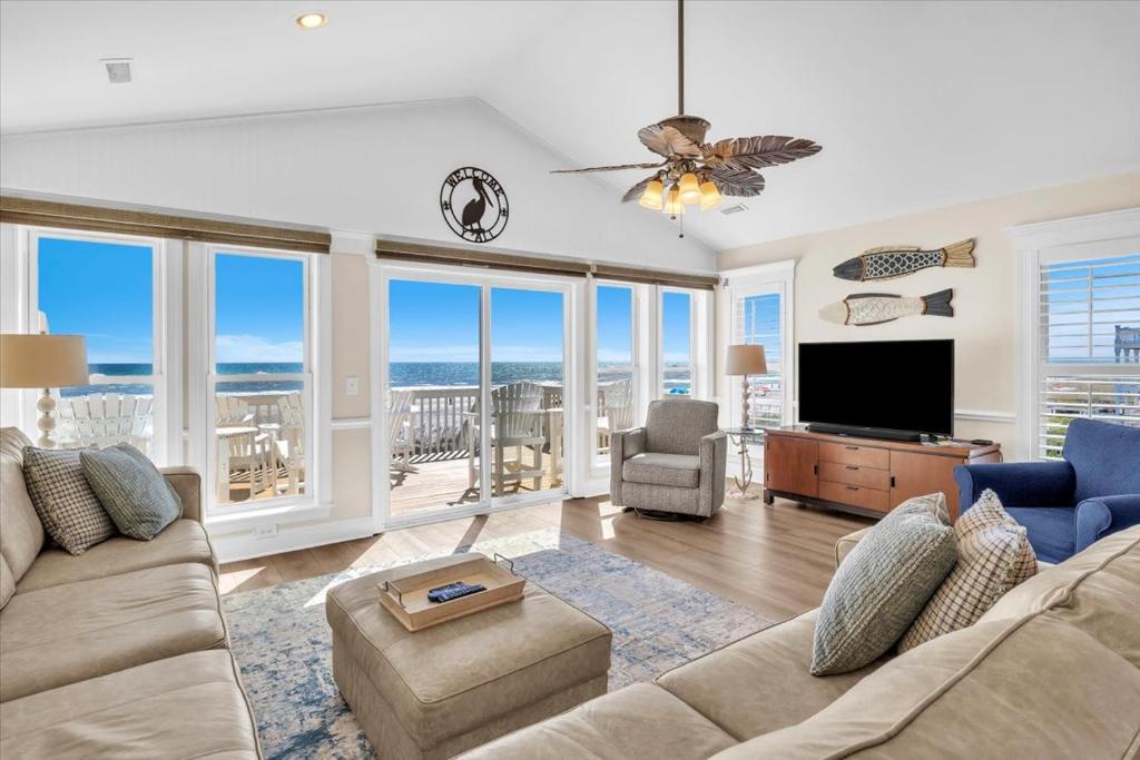 a living room with a couch and a flat screen tv at Drift Away in Topsail Beach