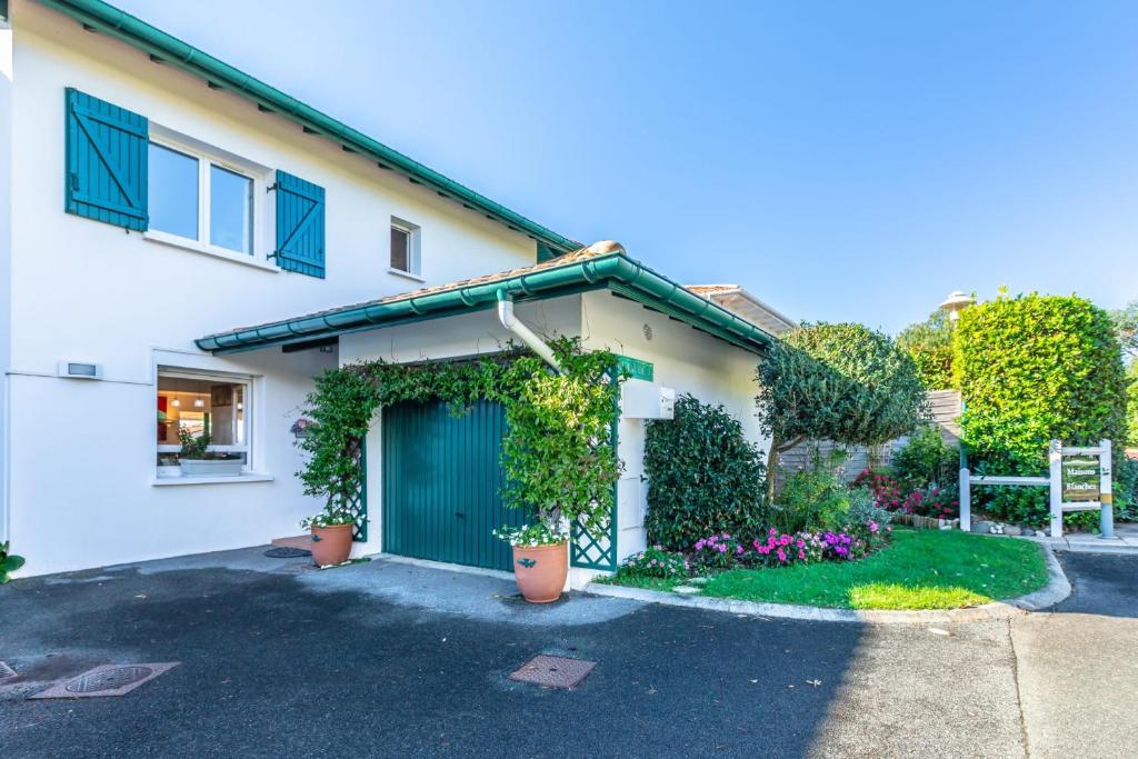 une maison avec une porte bleue et des plantes dans l'établissement Chambre d'hôtes-studette Biarritz Milady, calme, patio, vue sur jardin et montagne du patio, parkin privé, tout confort, à Biarritz