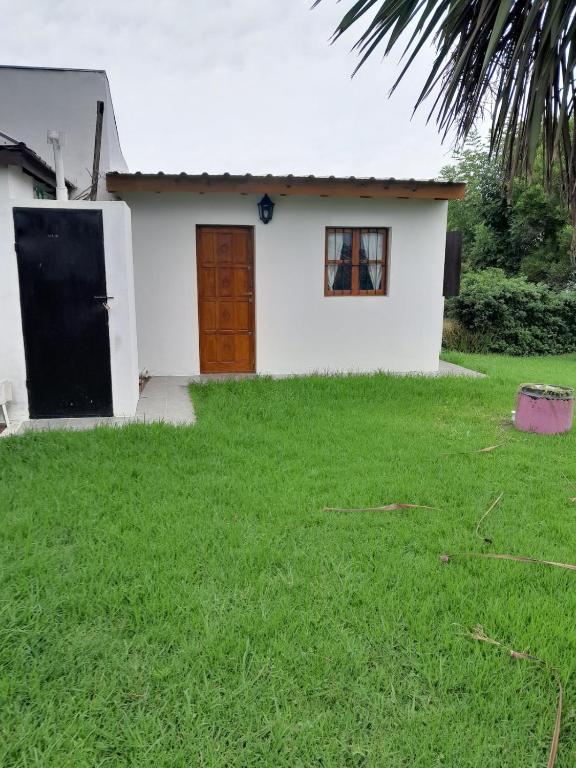 ein kleines weißes Haus mit einer Tür und einem Hof in der Unterkunft Casa de ensueño a pasos del mar in Camet Norte