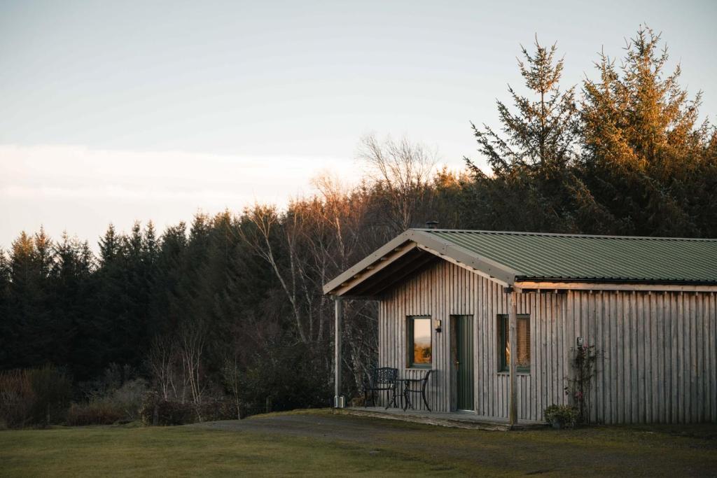 a small shed with a table and chairs in a yard at The Bothy at Coneloch in Elgin