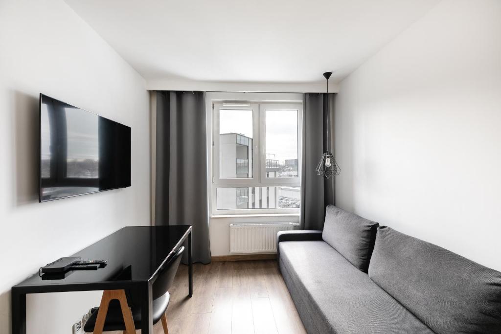 a living room with a couch and a table at Apartamenty Platinex 1 in Krakow