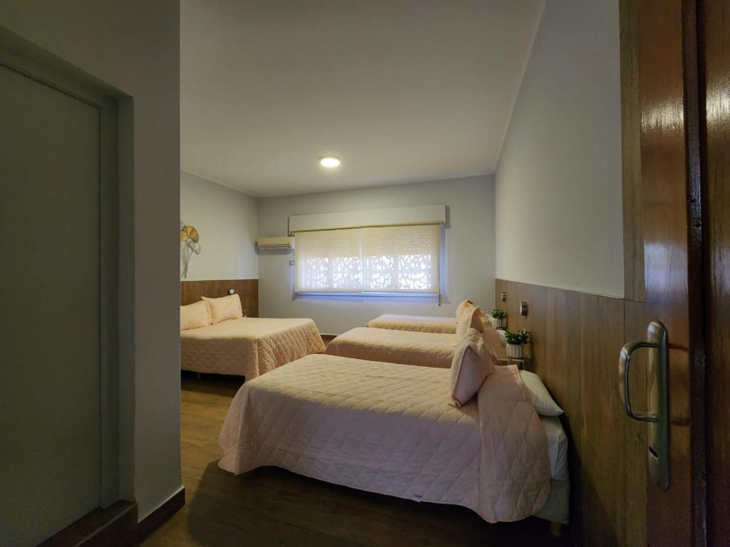 サン・ラファエルにあるAlas Hotelのベッド2台と窓のある寝室