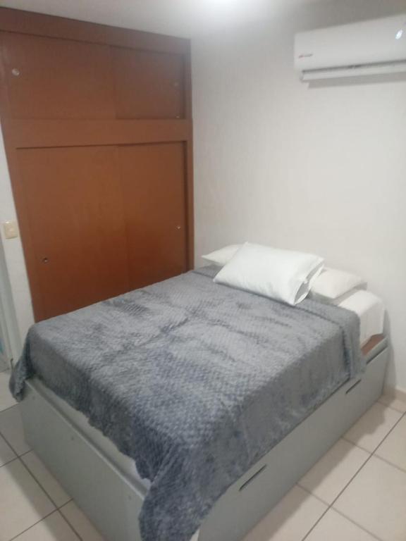 a small bedroom with a bed with a wooden cabinet at Casa Lisboa in Puerto Vallarta