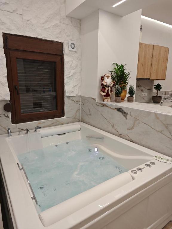 a large bath tub filled with water in a bathroom at Lūma Retreat in Kastoria