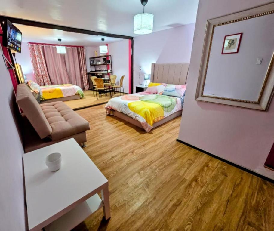 a bedroom with a bed and a table and a mirror at Suite Rosa familiar para hasta 6 huéspedes Amplia, céntrica, con cocineta y baño privado in Mexico City