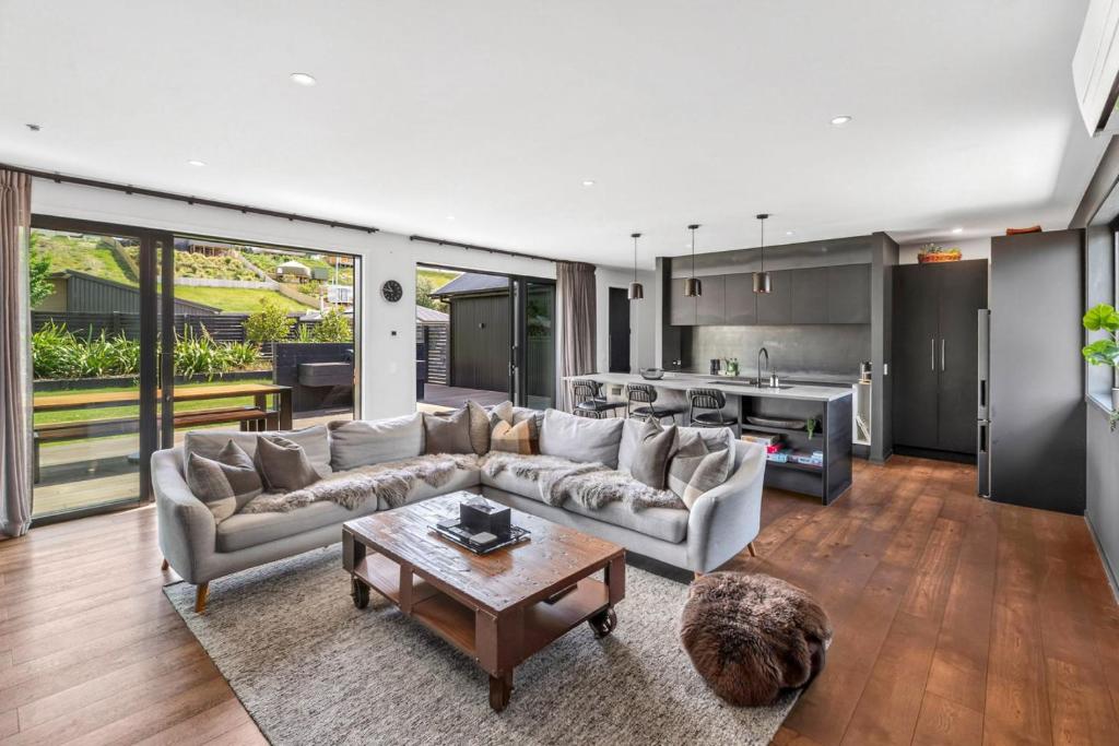 a living room with a couch and a table at Luxury Hāwea, Alfresco Retreat, Sleeps 6 in Lake Hāwea