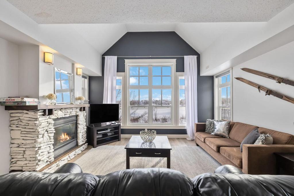 ein Wohnzimmer mit Sofa und Kamin in der Unterkunft Rivergrass Home with Mountain and Golf Course Views in Blue Mountains