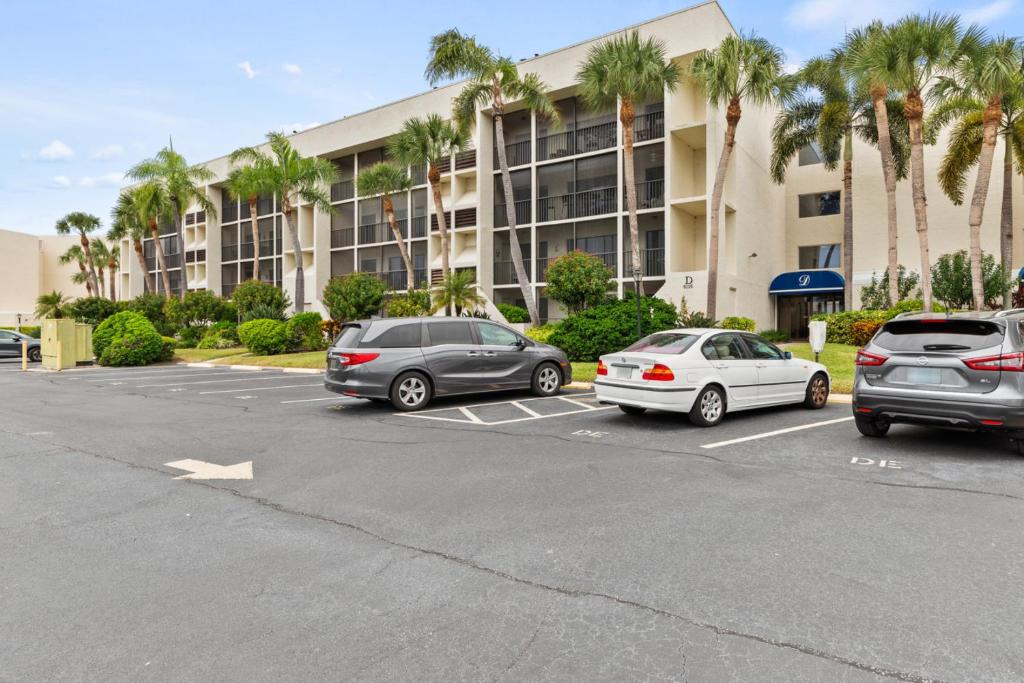 three cars parked in a parking lot in front of a building at IMG Condo Near Golf Course in Bradenton