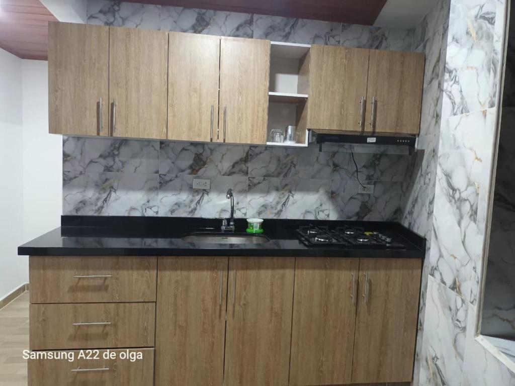 een keuken met houten kasten en een aanrechtblad bij Casa punta del este in Paipa