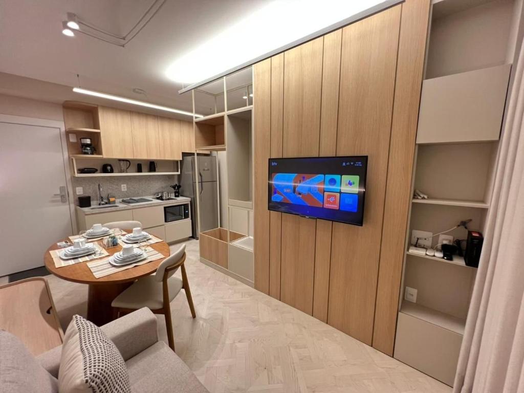 LK Centro 11 في بيلو هوريزونتي: غرفة معيشة مع طاولة وتلفزيون على الحائط