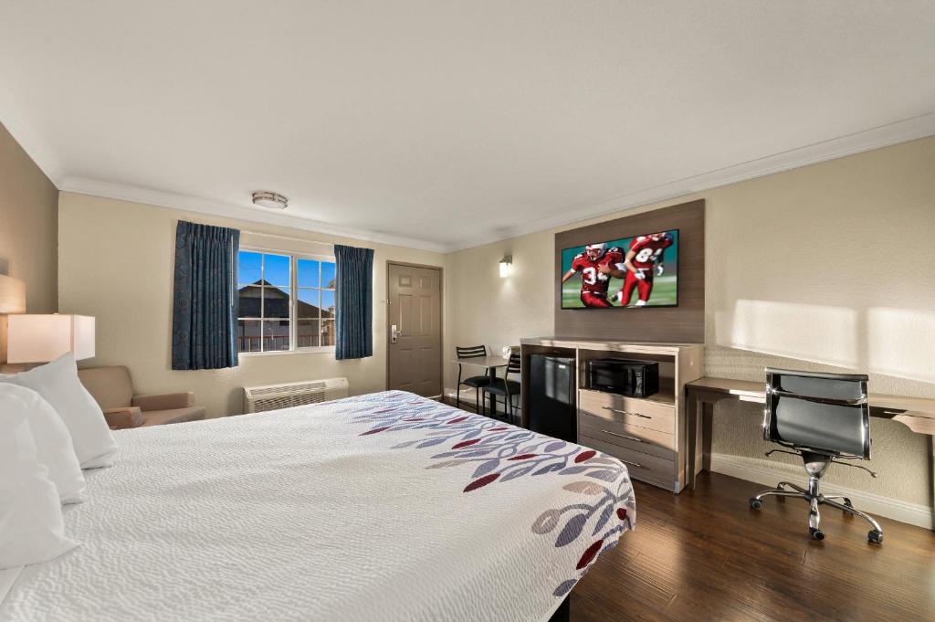 a hotel room with a bed and a desk at Red Roof Inn Los Angeles - Bellflower in Bellflower