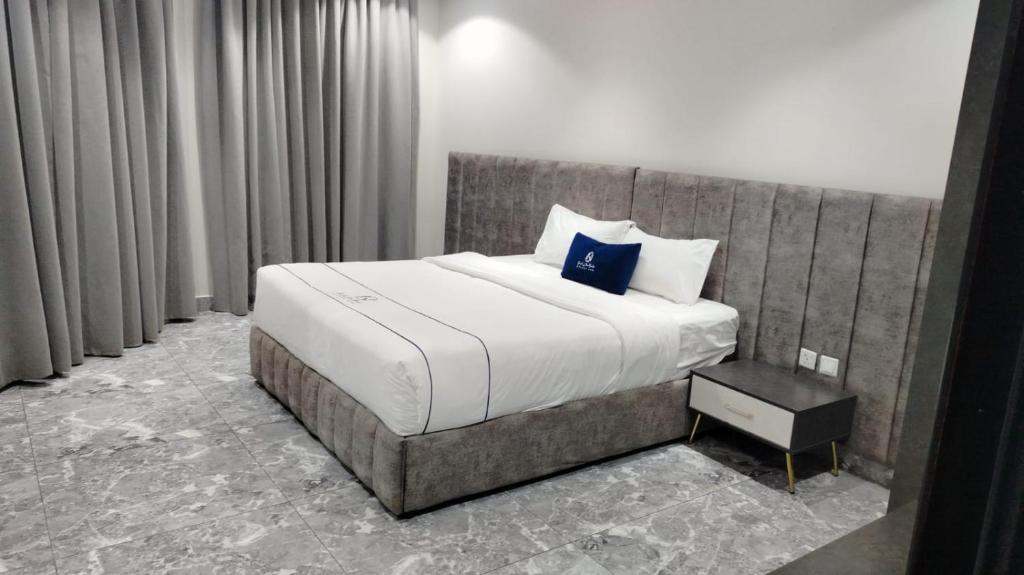een slaapkamer met een groot bed met een blauw kussen bij فندق جولدن نيو جوان HOTEL GOLDEN NEW jWan in Abha