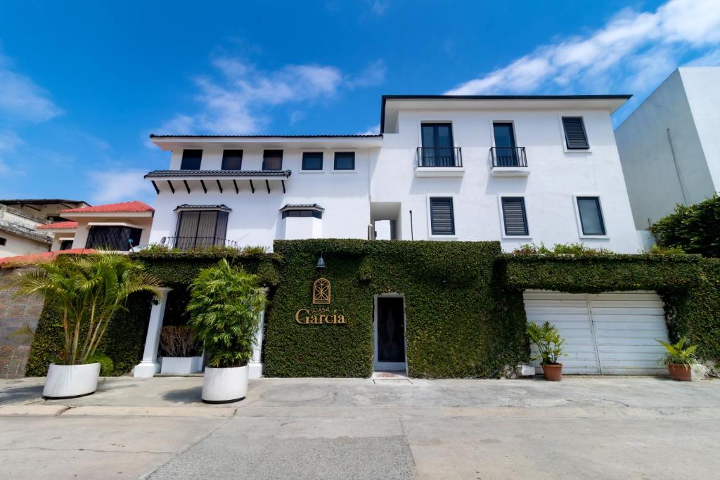a white house with a ivy covered building at Casa García in Guayaquil