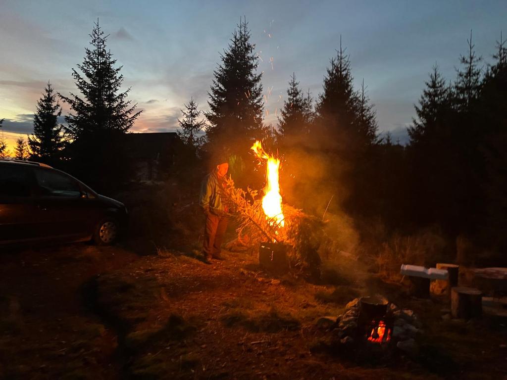 un uomo in piedi accanto a un falò di Adriana Phoenix's Bird a Horezu