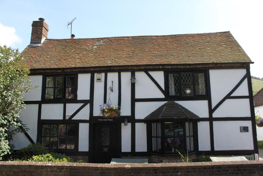 um antigo edifício a preto e branco com uma janela em B&B South Downs Way em Poynings