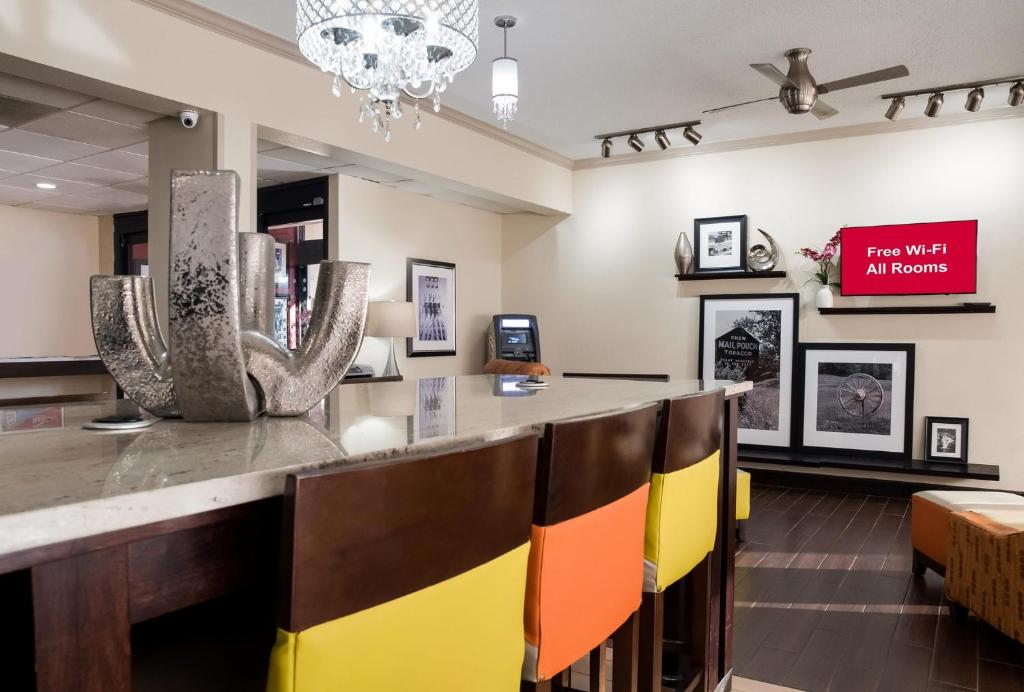 a lobby with a bar with colorful chairs at Red Roof Inn Tupelo in Tupelo