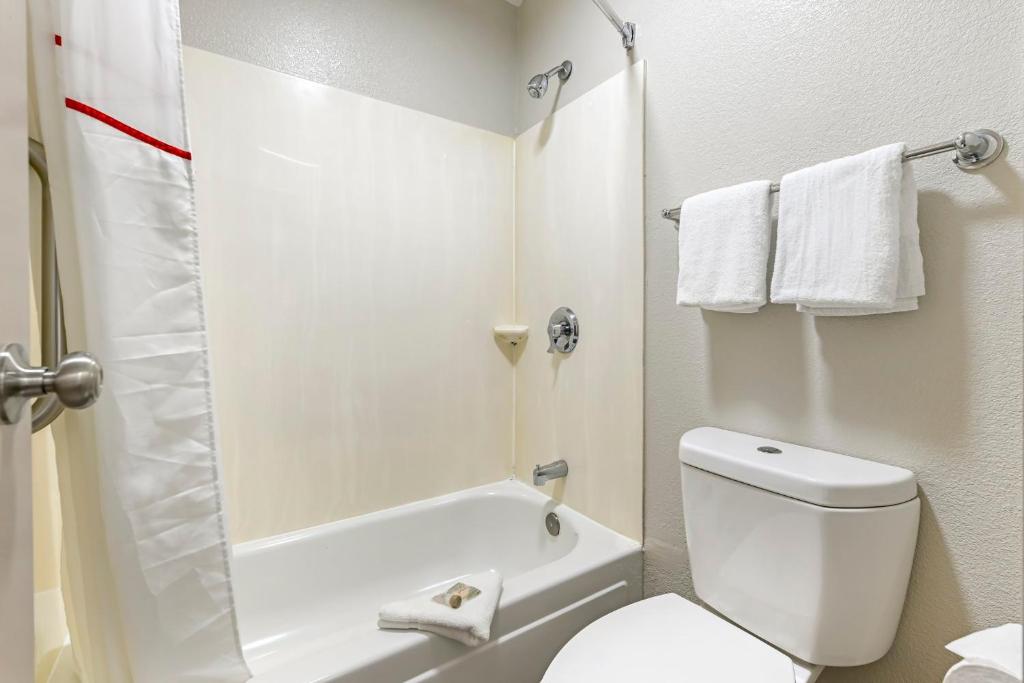 a white bathroom with a toilet and a shower at Red Roof Inn Washington DC - Laurel in Laurel