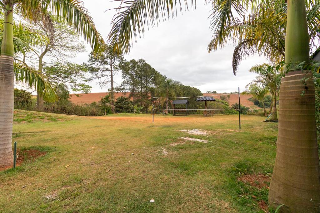 un parco con canestro da basket e palme di Kitnet 03 Pet friendly com Wi-Fi e Garagem a Bragança Paulista