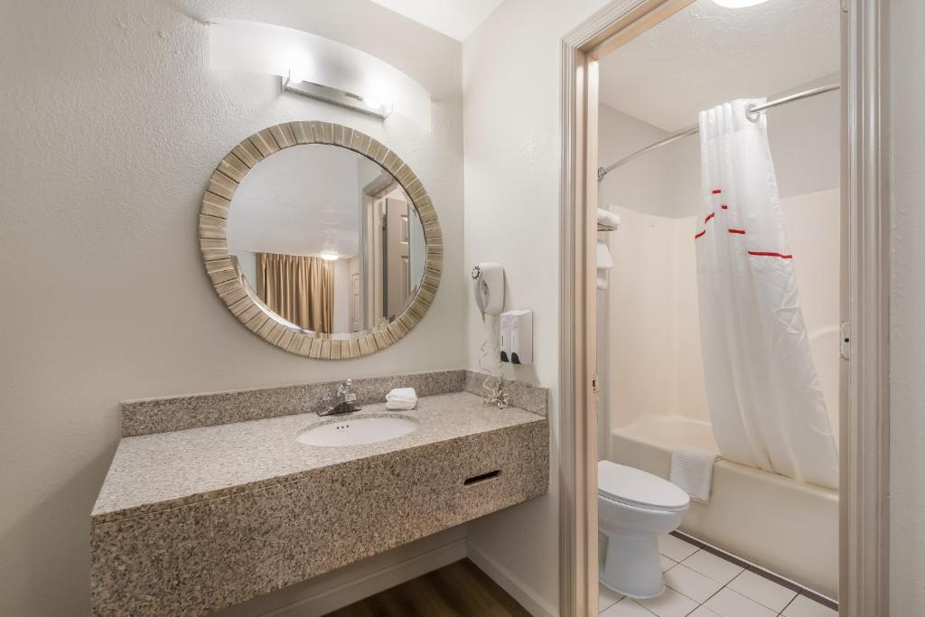 a bathroom with a sink and a toilet and a mirror at Red Roof Inn Crossville in Crossville