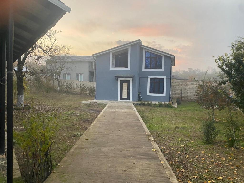 a blue house with a walkway in a yard at Дом в Гусаре in Qusar