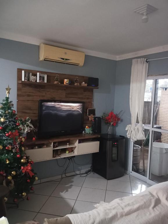 un soggiorno con albero di Natale e TV di Casa ap a Bertioga