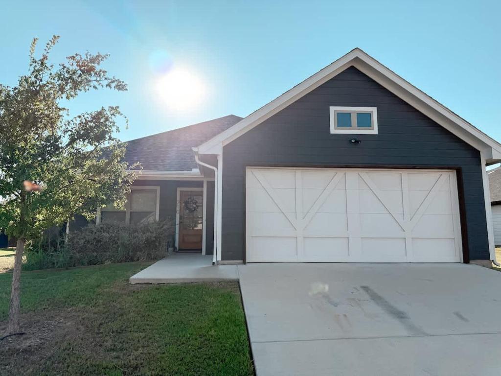 ein graues Haus mit einer Garage mit einem weißen in der Unterkunft Beautiful 3BD 2B - Weatherford - Same Day Bookings in Weatherford