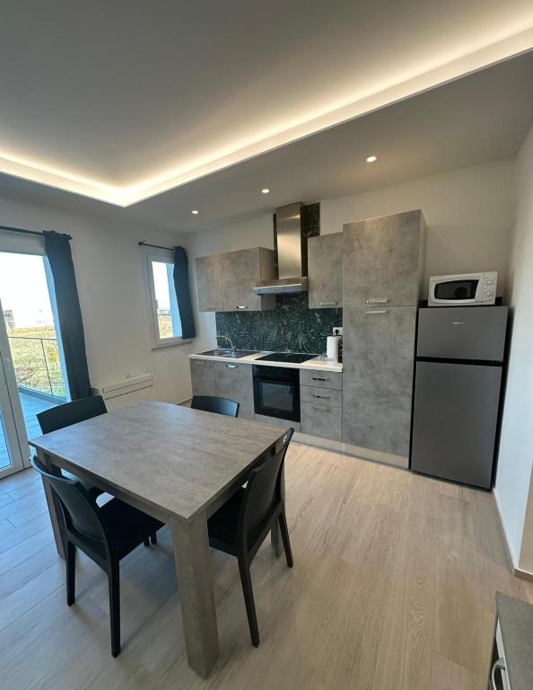 a kitchen with a table and chairs in a kitchen at Appartamento Cataleya in Cuccurano