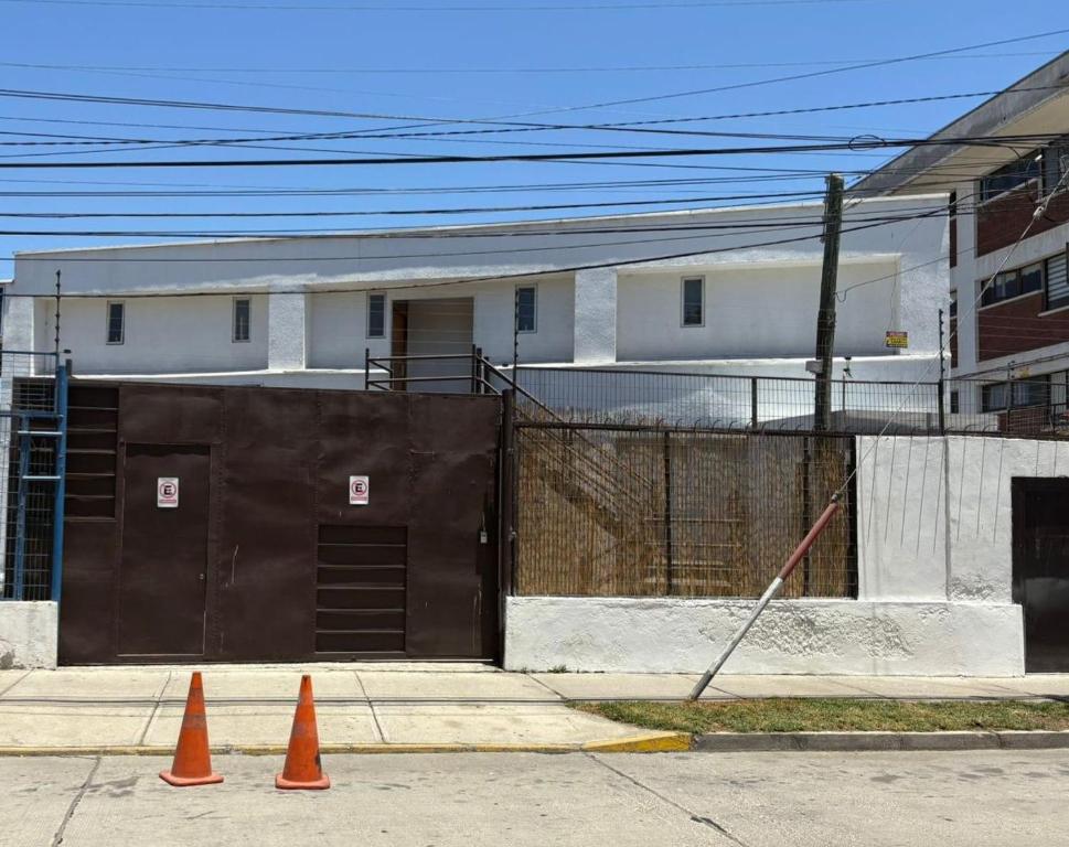due coni arancioni su un marciapiede di fronte a un edificio di Hermosos Departamentos en La Serena a La Serena