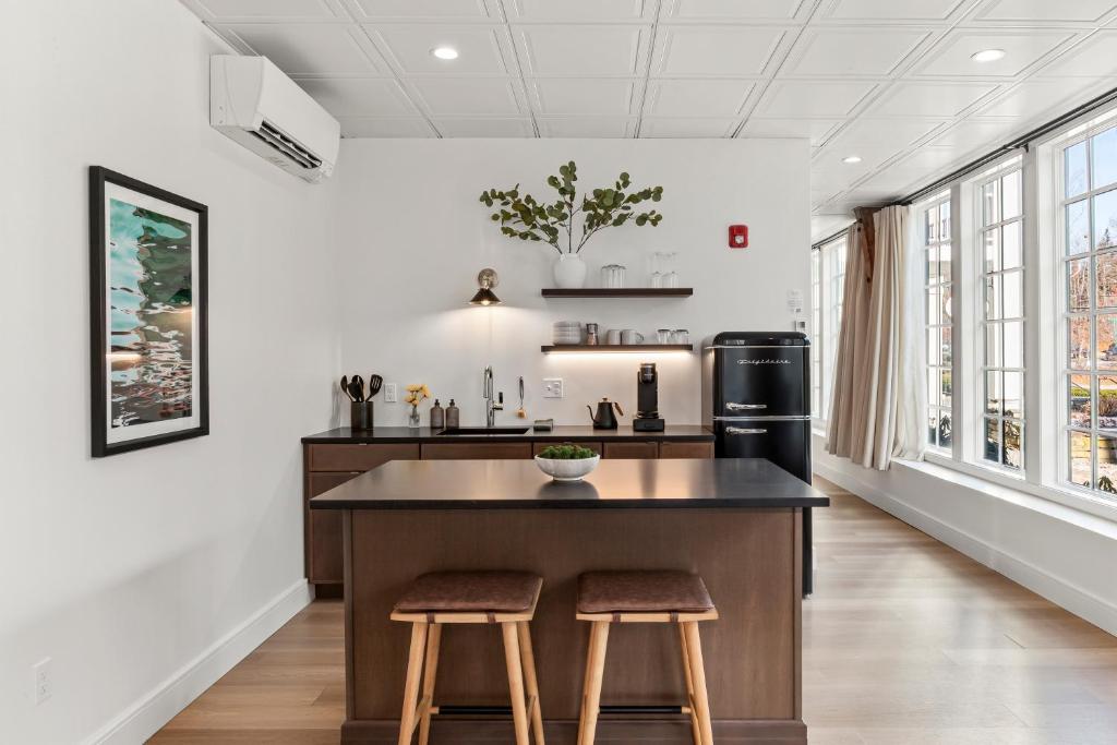 una cucina con una grande isola con due sgabelli di The Optimist Guesthouse | 1 a Camden