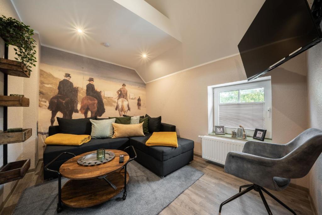 un soggiorno con un divano e un tavolo di Küsten Suite Burghaus 5, 60qm a Krummhörn
