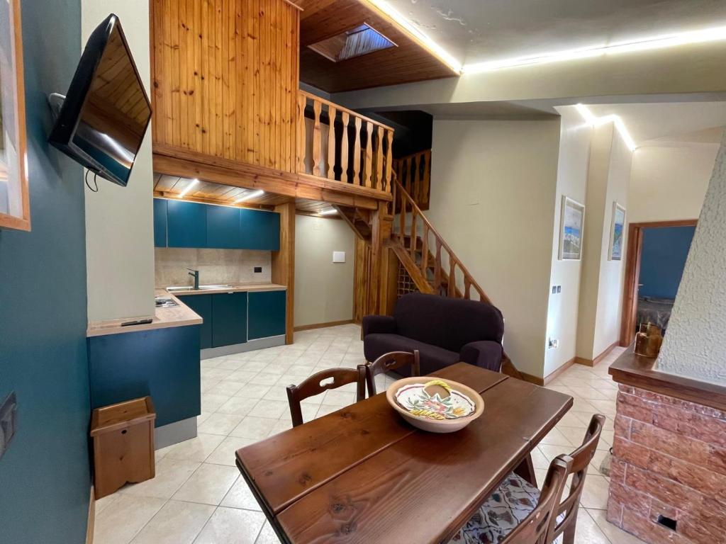 un soggiorno con tavolo in legno e una cucina di Montaria Suite a Pescocostanzo