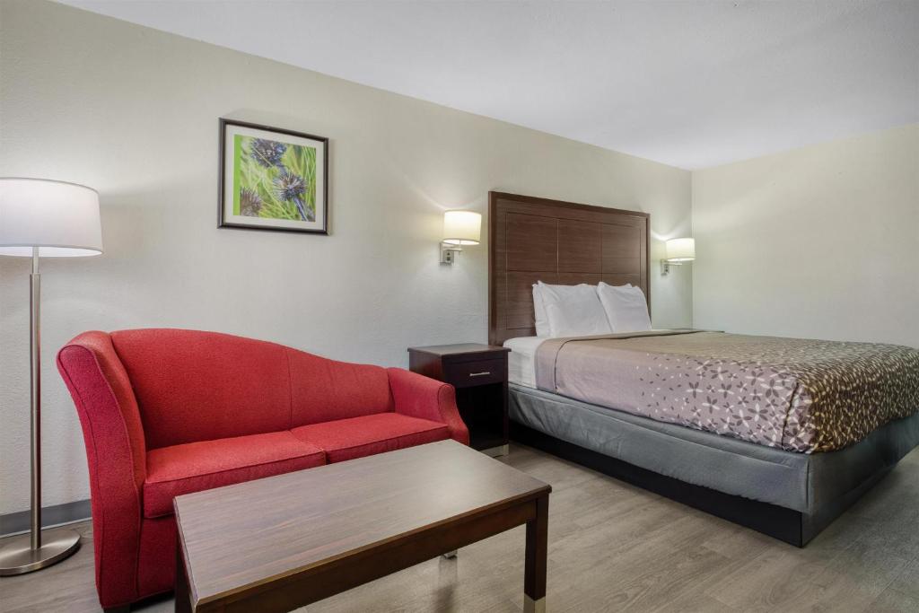 a hotel room with a bed and a red chair at SureStay Hotel by Best Western Terrell in Terrell