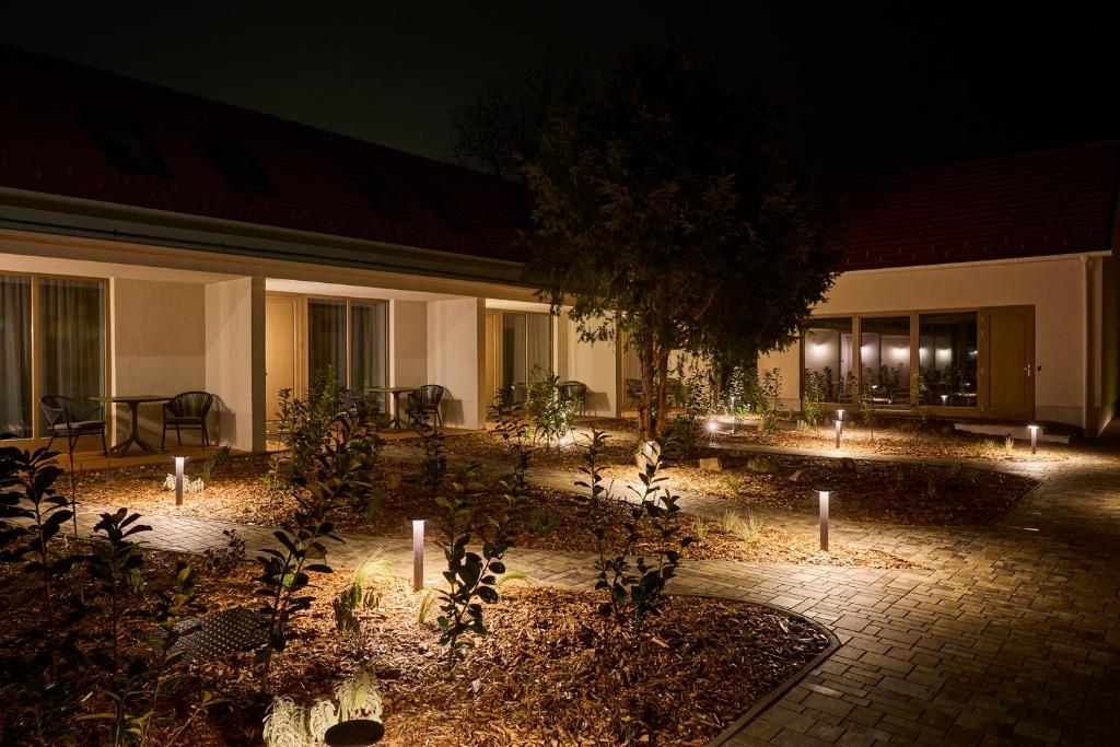 un patio de una casa por la noche con luces en Villa Bayer, en Villány