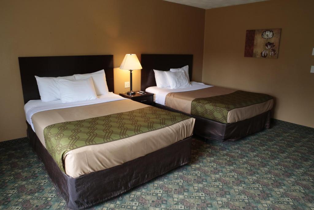 a hotel room with two beds and a lamp at Econo Lodge Inn & Suites Munising Area in Wetmore