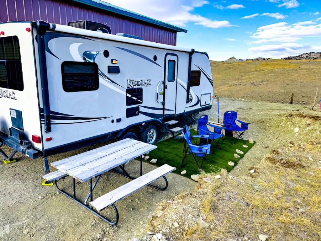 een witte trailer met stoelen en een bank ernaast bij Camper Adventure in Livingston