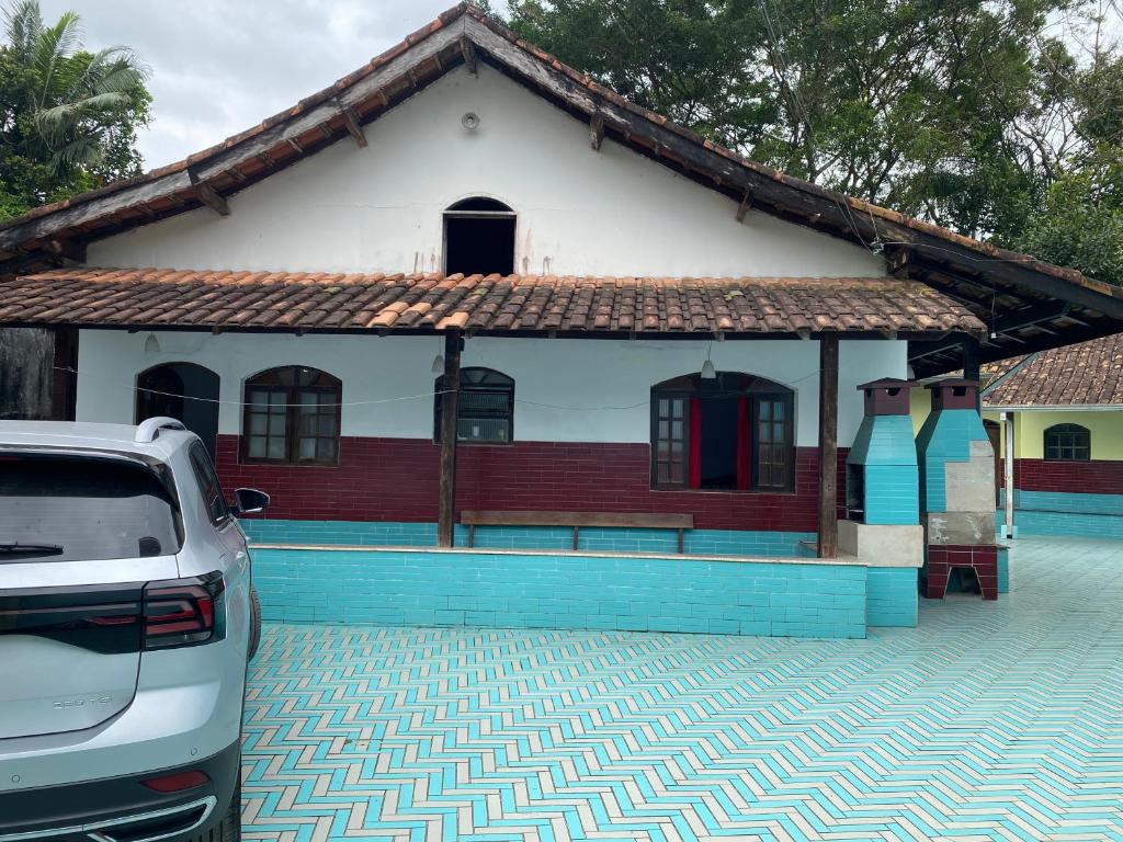 a house with a car parked in front of it at Casa de Praia Bertioga-Costa do Sol Guaratuba in Bertioga