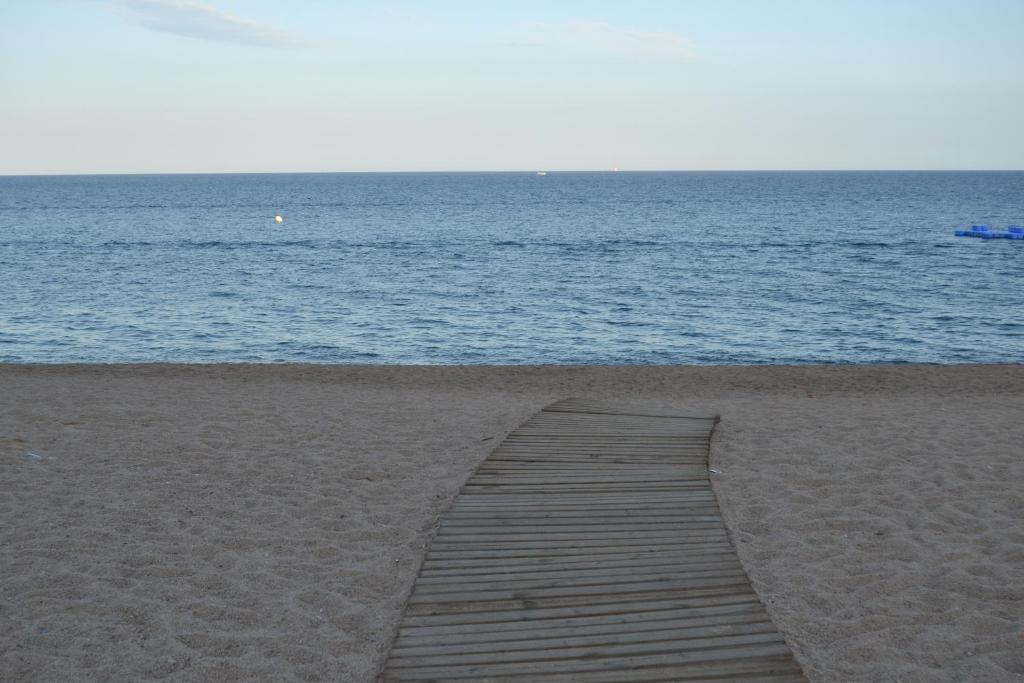 a wooden boardwalk on a beach near the water at Apartment Sun & Beach in Platja d'Aro in Platja d'Aro