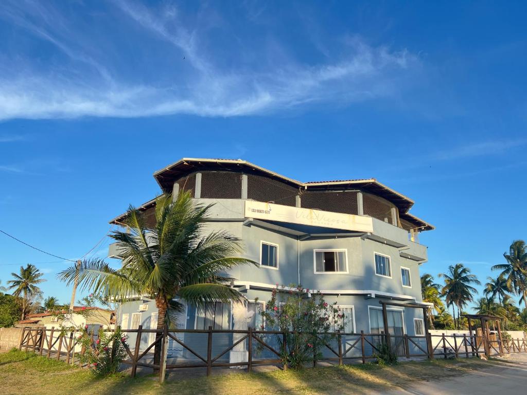 een groot huis met een palmboom ervoor bij Pousada Recanto Vila Viçosa in Nova Viçosa