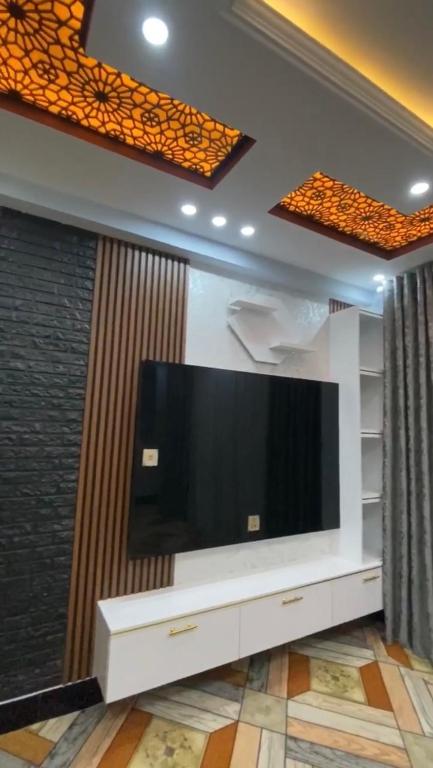 una grande TV a schermo piatto a parete in soggiorno di Madina plaza a Kabul