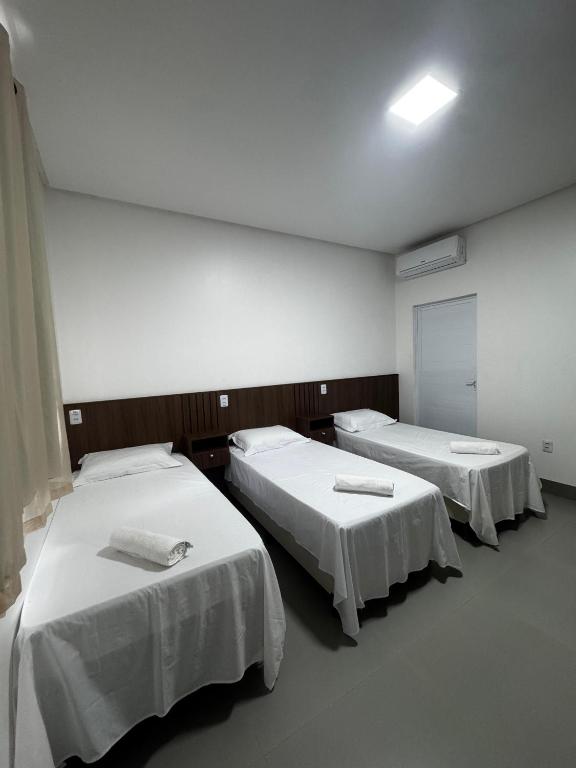 ボン・ジェズス・ダ・ラパにあるVilla Hotelの白いシーツを使用したベッド2台が備わる病室です。