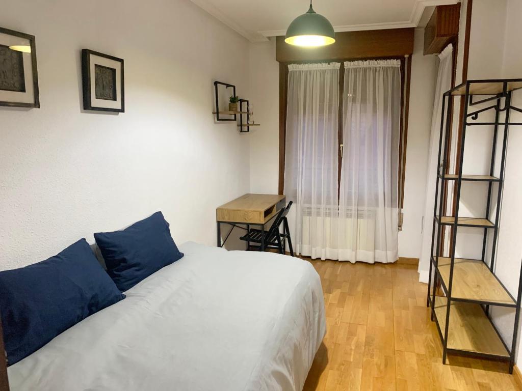 een slaapkamer met een bed met blauwe kussens en een ladder bij Casa Los Tios in Aldeanueva de Ebro